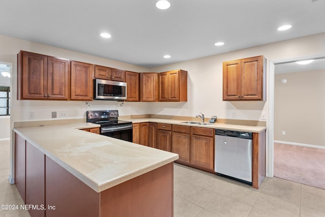 kitchen with kitchen peninsula, appliances with stainless steel finishes, light tile patterned floors, and sink