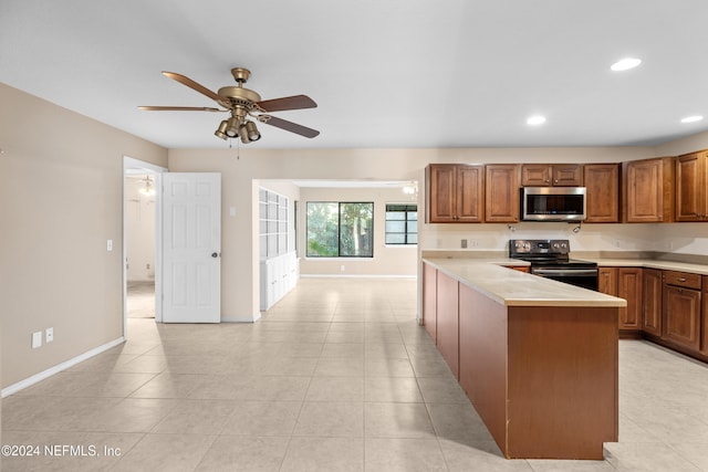 kitchen with ceiling fan, light tile patterned floors, and appliances with stainless steel finishes