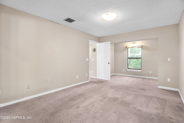 carpeted spare room with a textured ceiling