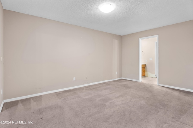 carpeted spare room featuring a textured ceiling