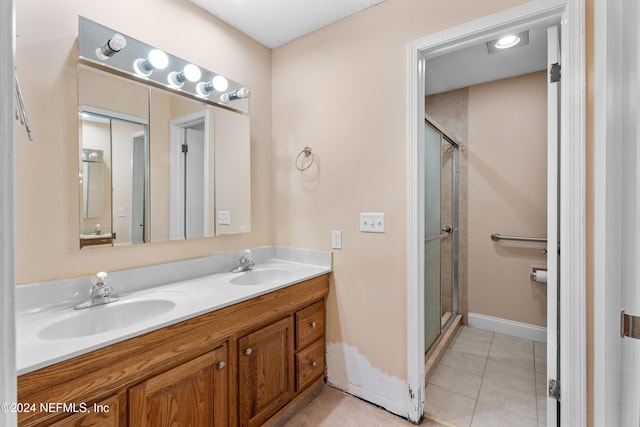 bathroom with vanity, tile patterned floors, and a shower with door