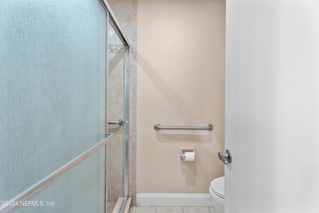 bathroom with tile patterned floors, an enclosed shower, and toilet