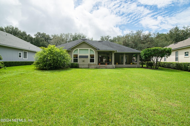 rear view of property with a yard