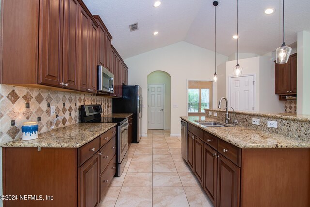 kitchen with a sink, visible vents, vaulted ceiling, hanging light fixtures, and appliances with stainless steel finishes