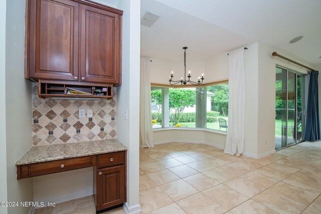 kitchen with light tile patterned floors, light stone counters, visible vents, and decorative backsplash