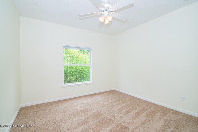 spare room with carpet, ceiling fan, and baseboards