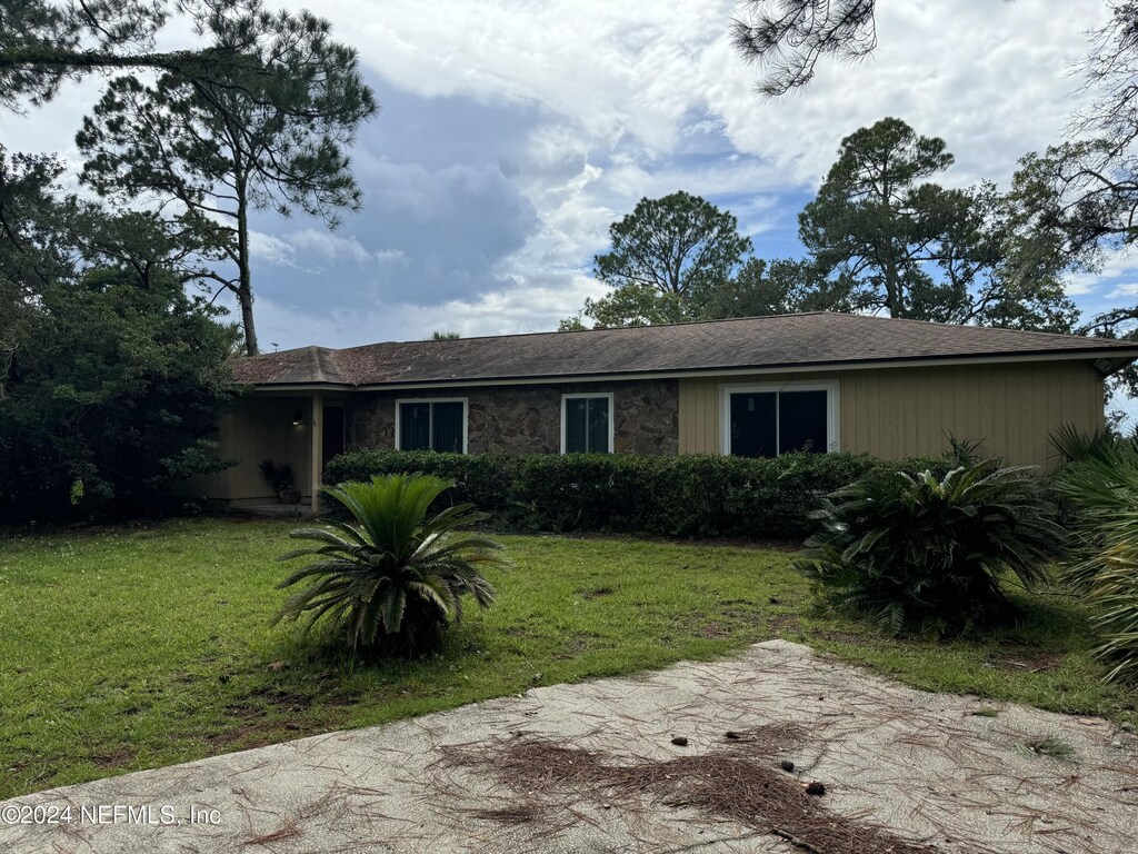 single story home with a front lawn