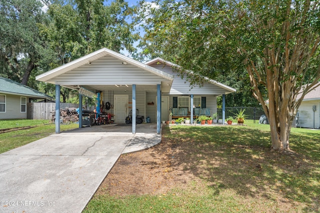 view of front of home with a front yard, a carport, and a porch