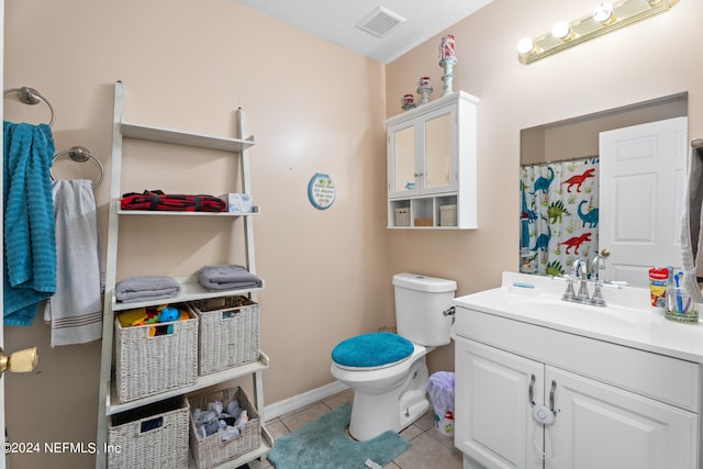 bathroom with tile patterned floors, toilet, a textured ceiling, and vanity