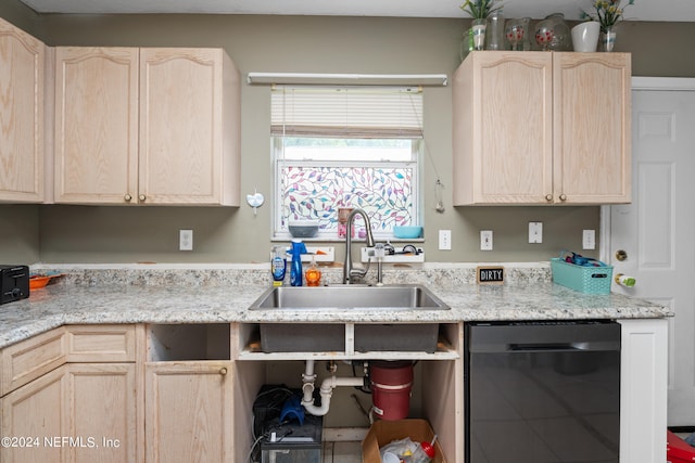 kitchen with black dishwasher, light stone countertops, sink, and light brown cabinets