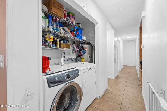 laundry room with washer and dryer, light tile patterned floors, and water heater