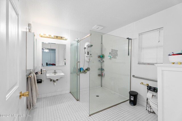 bathroom with toilet, a shower with shower door, sink, and tile patterned flooring