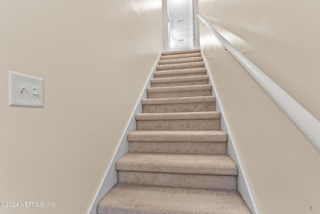 stairs featuring carpet flooring