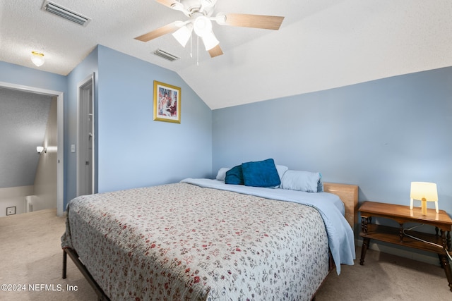 bedroom with a textured ceiling, vaulted ceiling, carpet floors, and ceiling fan