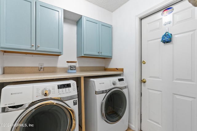 laundry room with cabinets, a textured ceiling, and washing machine and clothes dryer