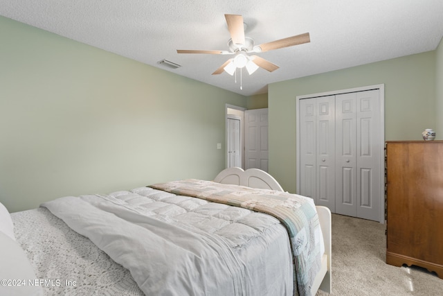 carpeted bedroom with a textured ceiling and ceiling fan