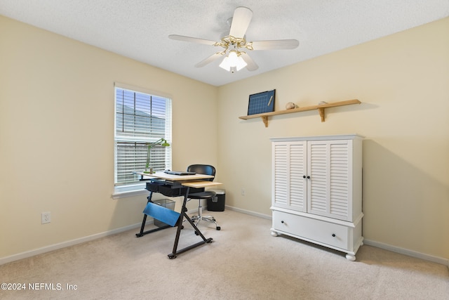 office space featuring light carpet, a textured ceiling, and ceiling fan