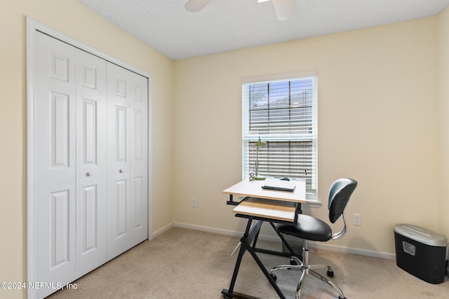 home office featuring a textured ceiling, light colored carpet, and ceiling fan