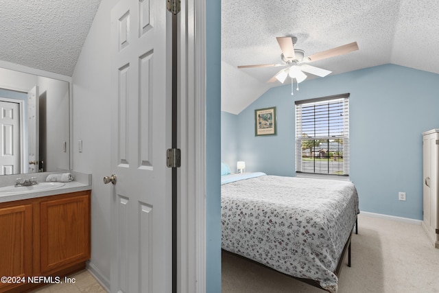 carpeted bedroom featuring lofted ceiling, sink, a textured ceiling, and ceiling fan