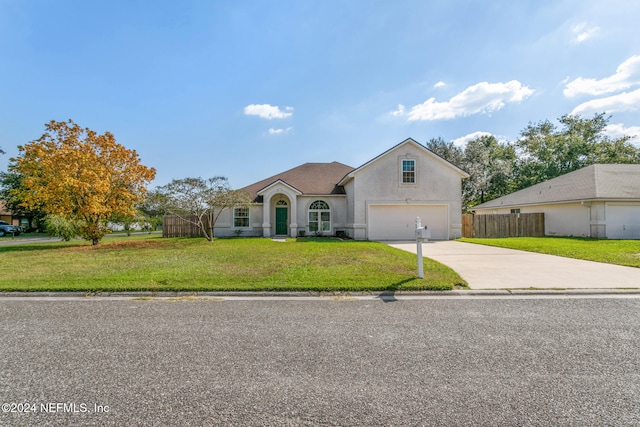 view of front of home with a front yard and a garage