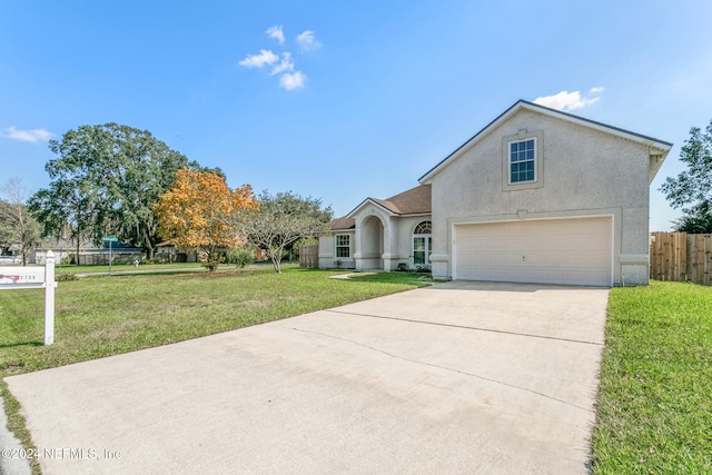 view of property featuring a front yard and a garage