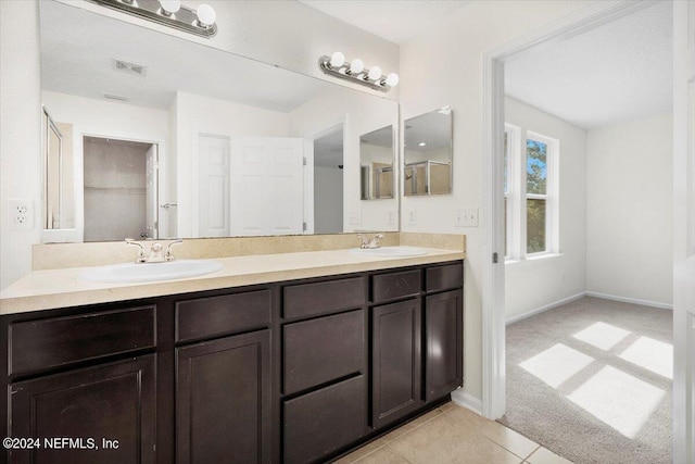 bathroom with tile patterned flooring, visible vents, a sink, and double vanity