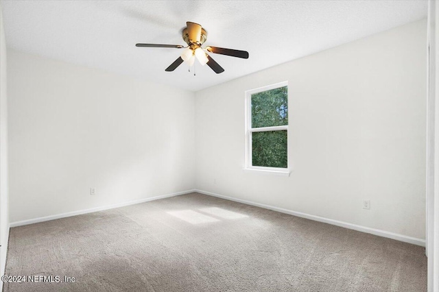 unfurnished room with ceiling fan, carpet floors, and baseboards