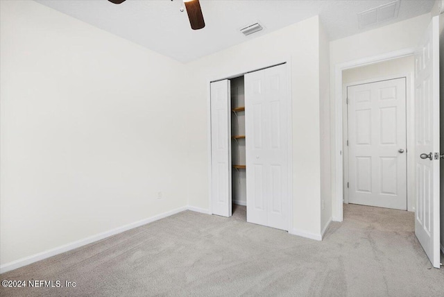 unfurnished bedroom with light carpet, baseboards, visible vents, and a closet