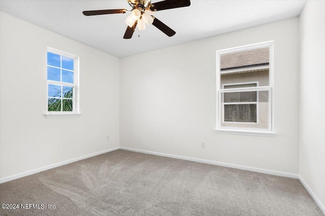 spare room featuring carpet floors, ceiling fan, baseboards, and a textured ceiling