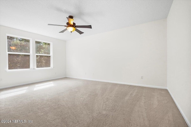 carpeted spare room with a textured ceiling, a ceiling fan, and baseboards