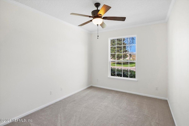 empty room featuring baseboards, a ceiling fan, a textured ceiling, crown molding, and carpet flooring