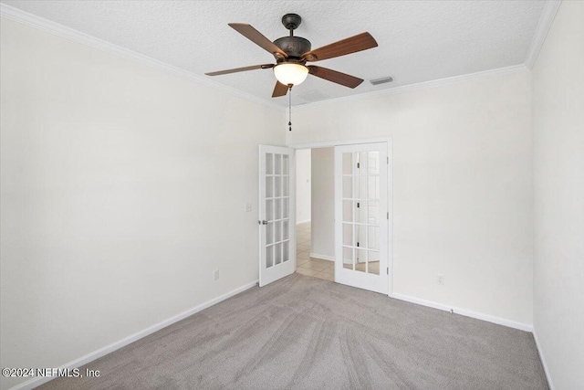 carpeted empty room featuring ornamental molding, french doors, a textured ceiling, and visible vents