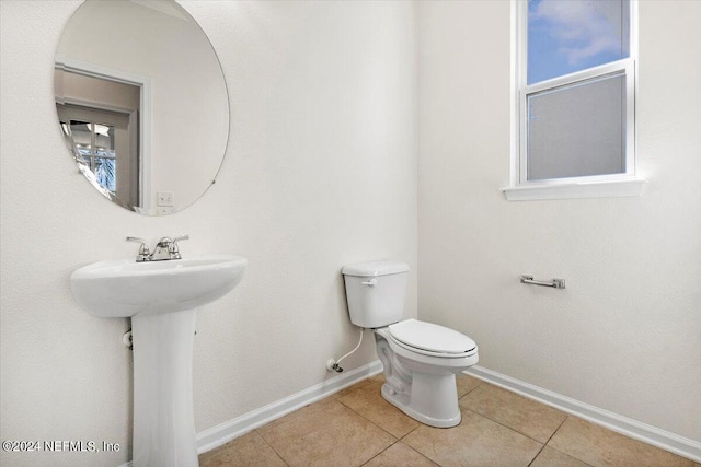 bathroom with tile patterned flooring, toilet, and baseboards