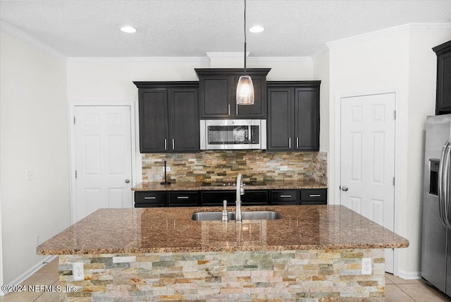 kitchen featuring appliances with stainless steel finishes, stone countertops, a sink, and decorative backsplash