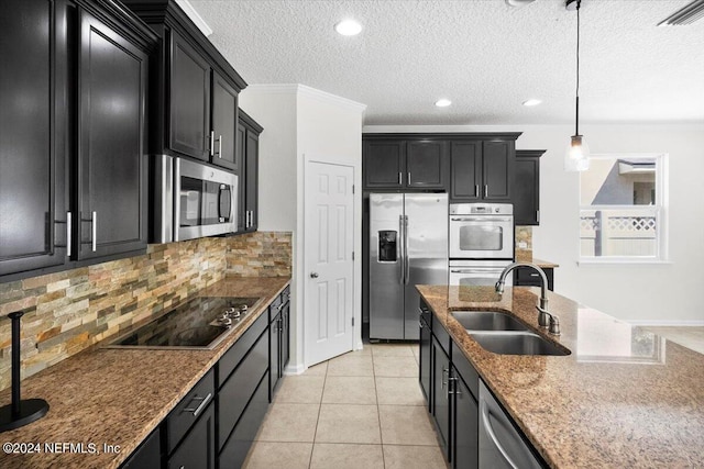 kitchen featuring stainless steel appliances, a sink, visible vents, and dark cabinets