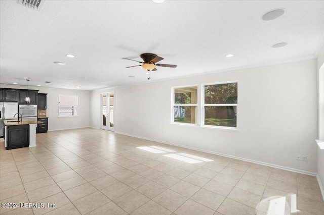 unfurnished living room with a ceiling fan, visible vents, baseboards, and light tile patterned flooring