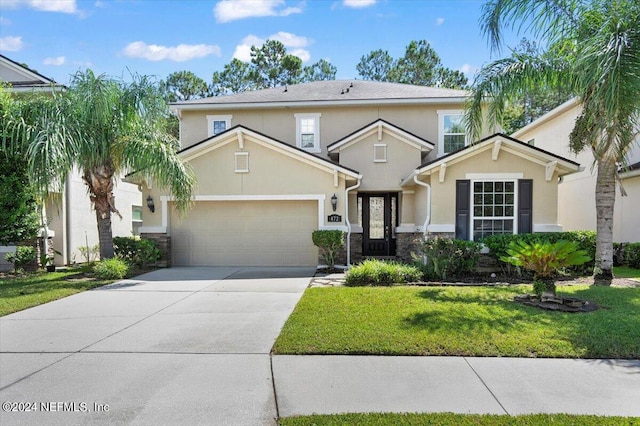 traditional-style home with a garage, concrete driveway, stone siding, a front lawn, and stucco siding