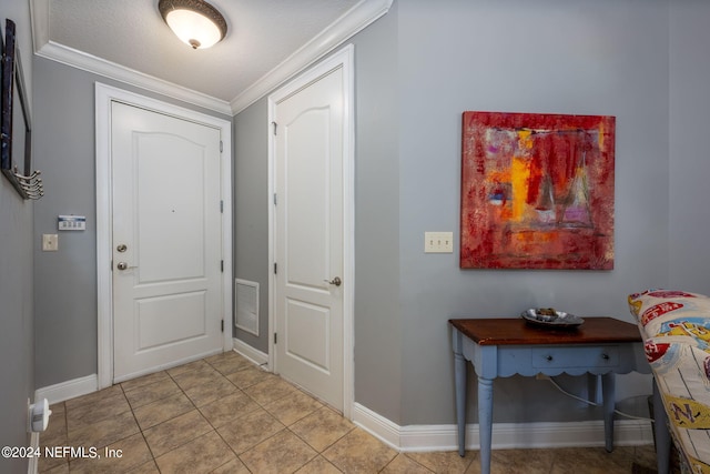 tiled entryway featuring crown molding