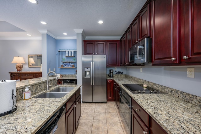 kitchen with light stone countertops, light tile patterned floors, black appliances, ornamental molding, and sink