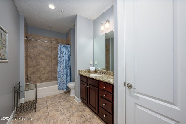 full bathroom with shower / tub combo, vanity, a textured ceiling, tile patterned flooring, and toilet