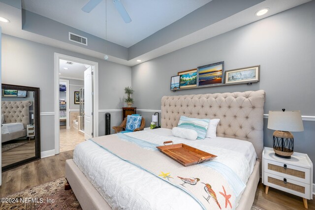 bedroom featuring connected bathroom, ceiling fan, and hardwood / wood-style floors