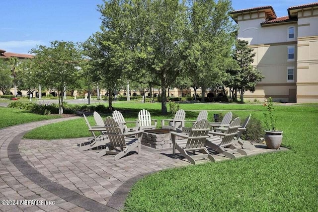 exterior space featuring a patio, a yard, and an outdoor fire pit