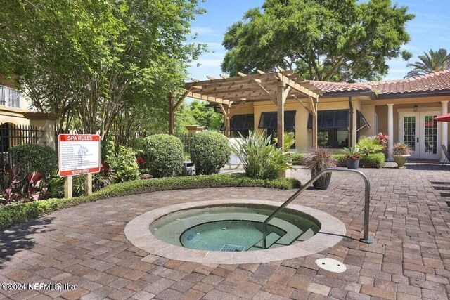 view of pool featuring a pergola, a hot tub, a patio area, and french doors