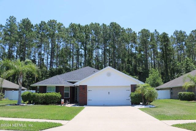 ranch-style house featuring a garage and a front lawn