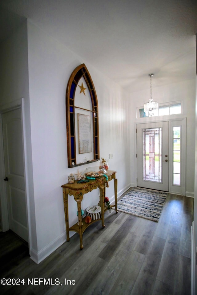 foyer with a notable chandelier and dark hardwood / wood-style floors