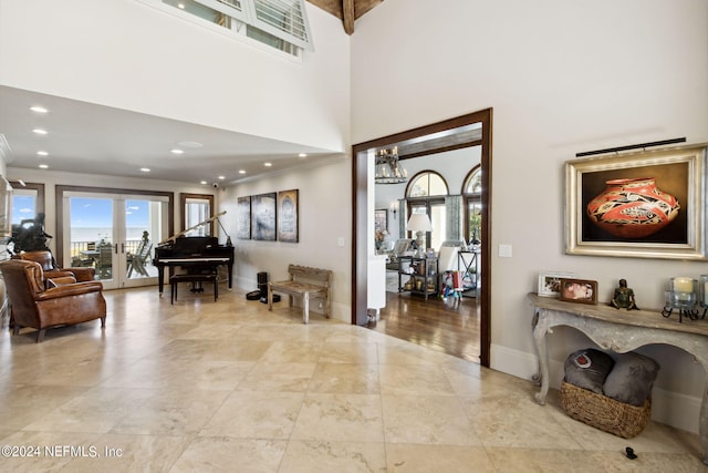 entryway with french doors, a notable chandelier, crown molding, and a high ceiling