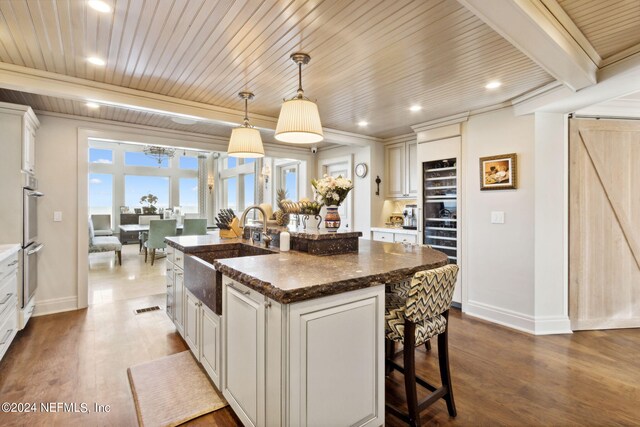 901 Ponte Vedra Blvd, Ponte Vedra Beach, FL 32082 - kitchen featuring dark wood-style flooring, a kitchen bar, a sink, baseboards, and a center island with sink
