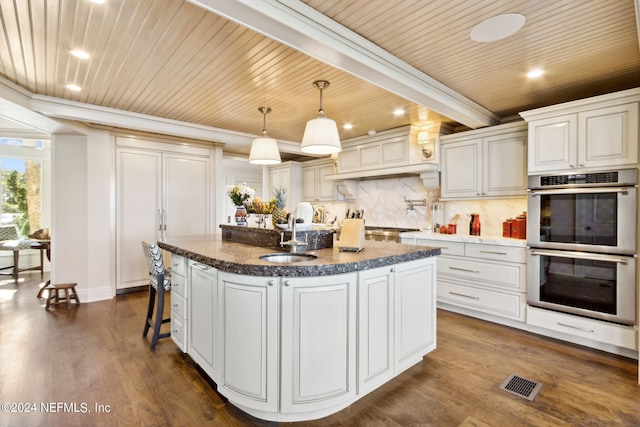 kitchen with dark wood-type flooring, sink, an island with sink, white cabinetry, and double oven