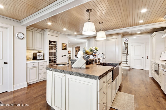 kitchen with an island with sink, hanging light fixtures, sink, wood-type flooring, and wooden ceiling