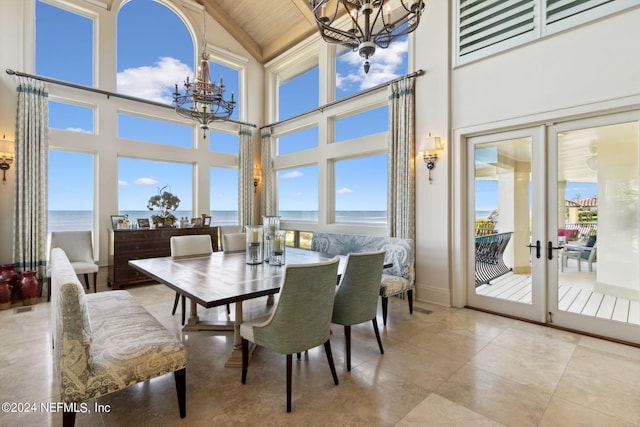 dining room with high vaulted ceiling, french doors, a water view, and a healthy amount of sunlight